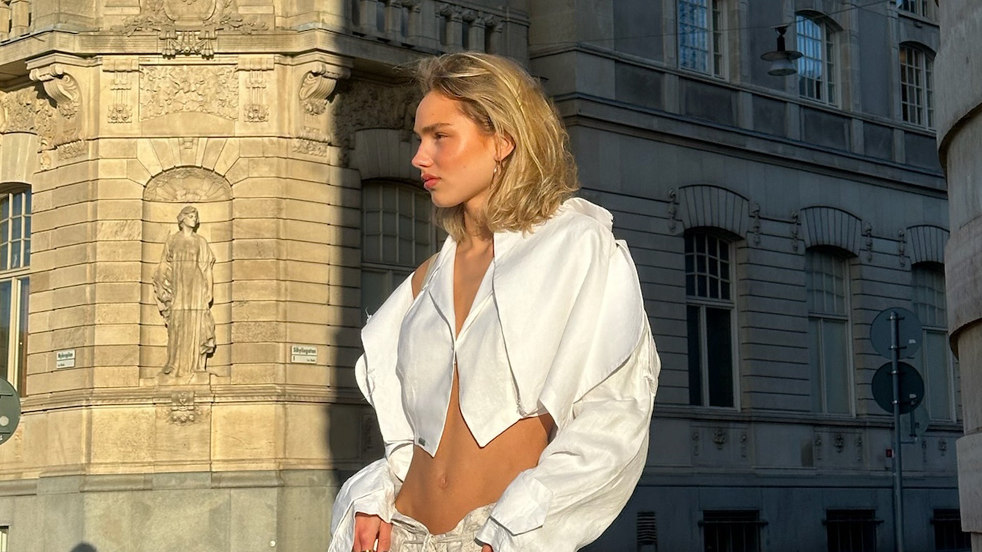 Woman in a white top poses outdoors
